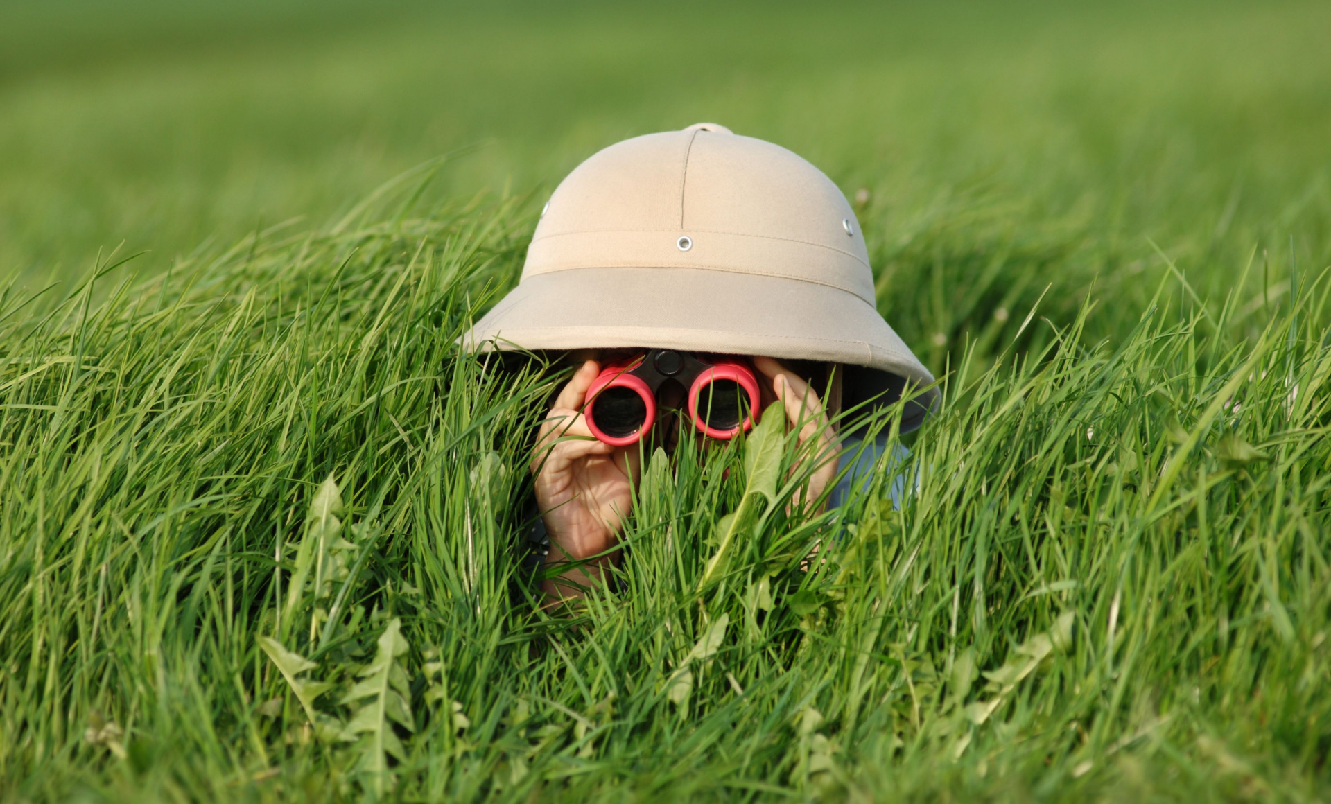 Kind met verrekijker in het gras.jpg
